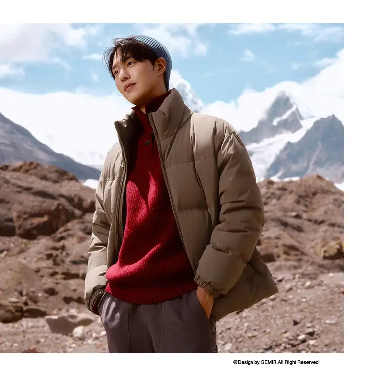 Semir tan down jacket, unisex puffer coat worn over a red sweater in a rocky mountain landscape