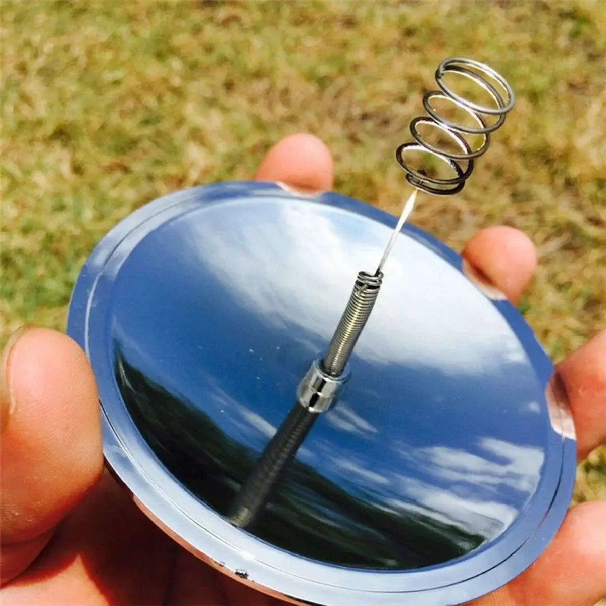 Solar lighter for outdoor fire ignition; compact reflective circular disk with spring-loaded igniter