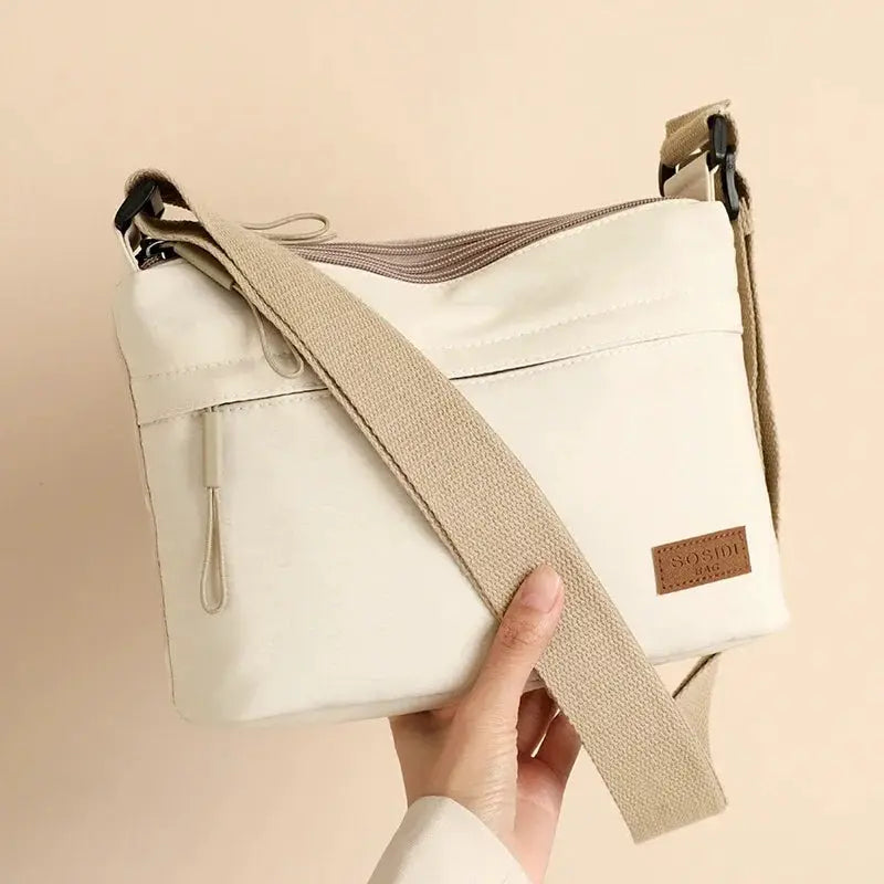 Canvas crossbody bag Simples Market with cream fabric and beige strap, three main pockets