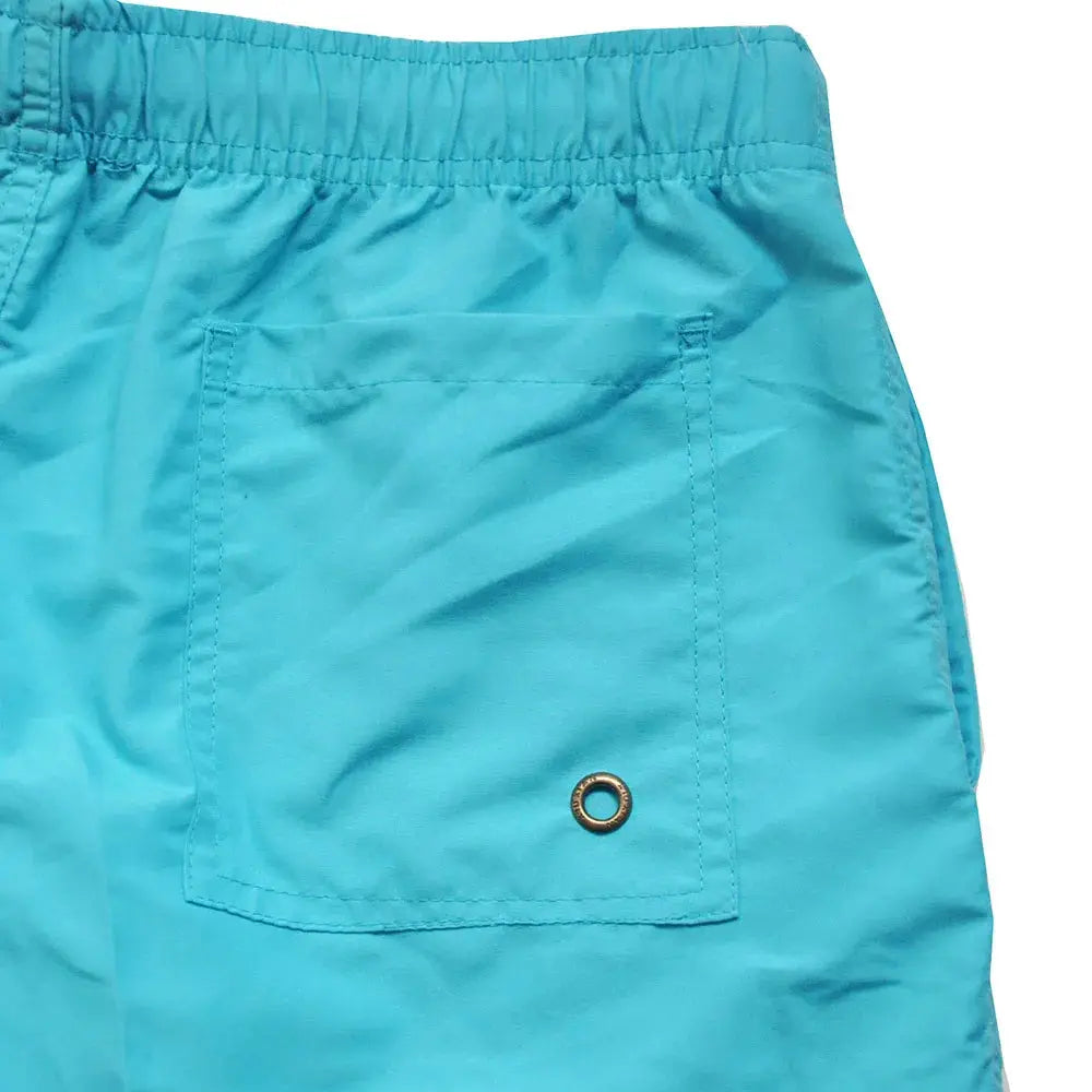 Turquoise swim trunks for men by Simples Market with elastic waistband and back pocket with metal grommet.