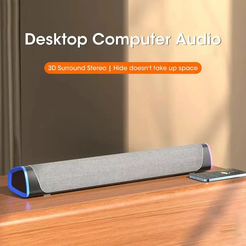 Niye Bluetooth speaker bar with subwoofer on desk, gray fabric grille, blue left edge, purple right accent