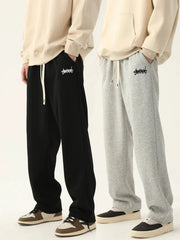 Men's jogging pants by Simples Market; baggy black and grey sweatpants with drawstrings and logo patches, two pairs