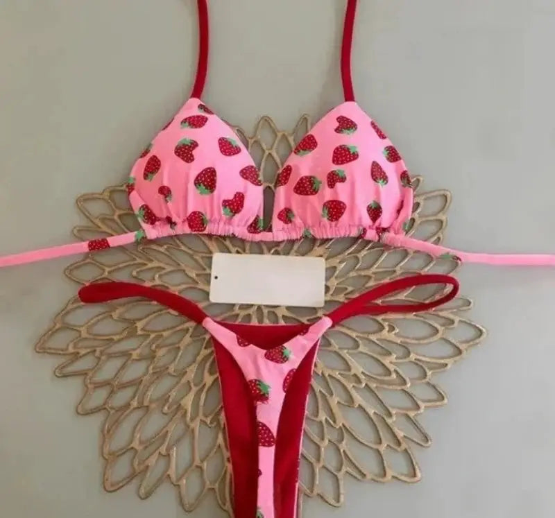 Simples Market strawberry-print bikini set; pink halter triangle top with red straps and matching pink thong bottom