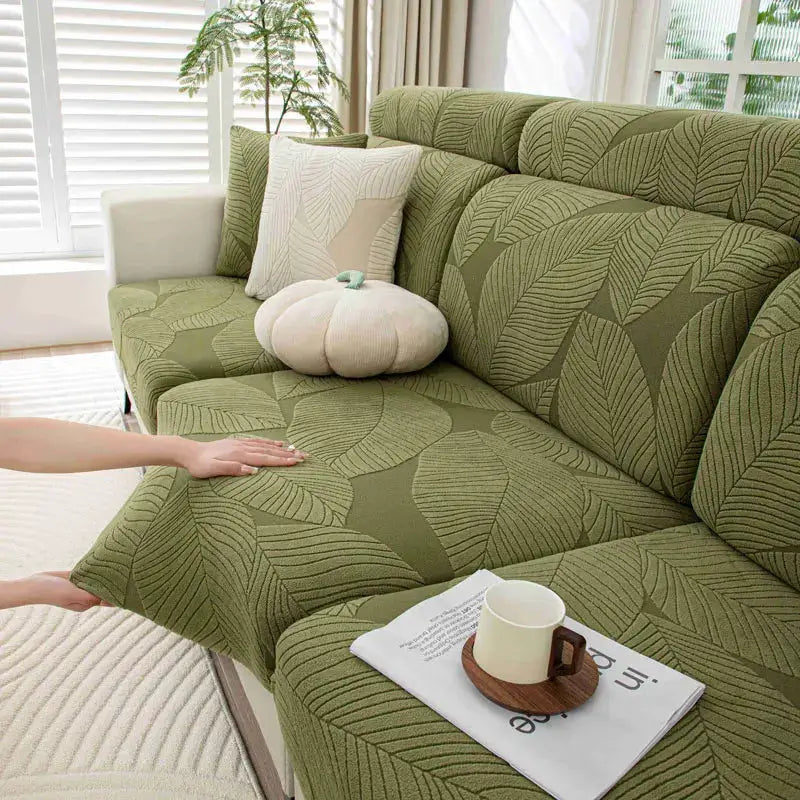 Sofa cover by Simples Market in thick plush olive green leaf-pattern fabric with elastic edges, removable