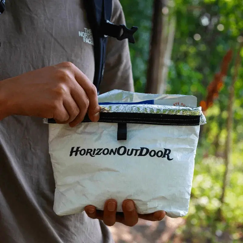 HorizonOutdoor Tyvek insulated food pouch, white, held by hiker wearing The North Face jacket.