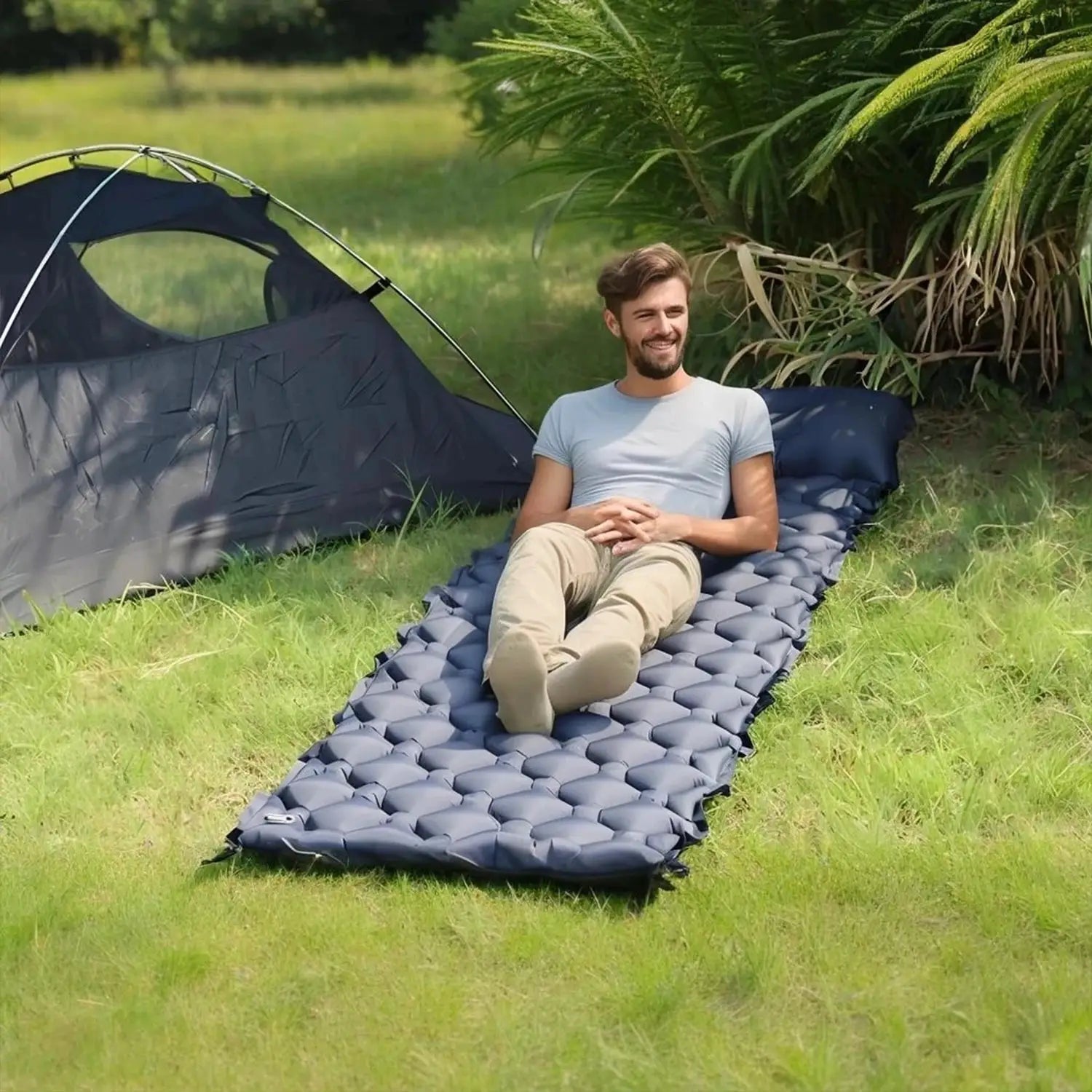 Simples Market inflatable sleeping pad camping mat, grey quilted air mattress on grass beside a man by a tent