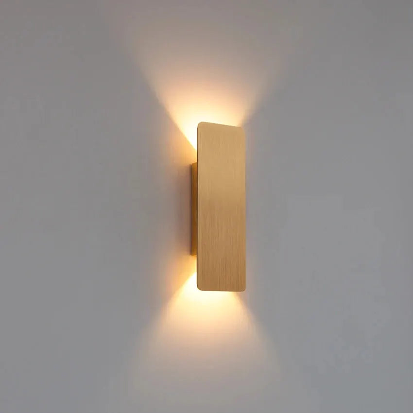 Modern LED wall lamp with a wooden rectangular block, emitting warm light up and down.