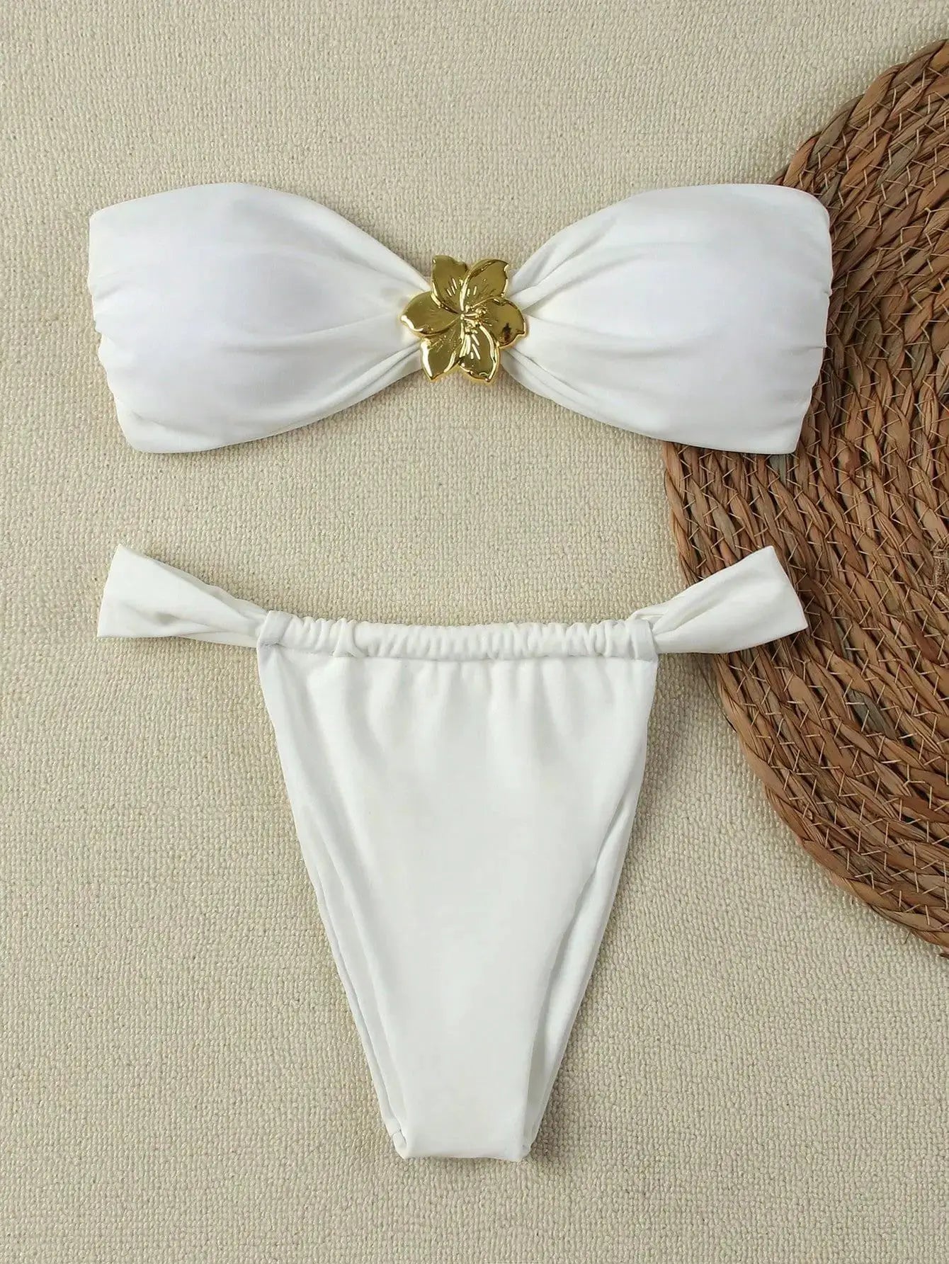 Simples Market white two-piece bandeau bikini set with gold flower centerpiece and Brazilian thong bottom.
