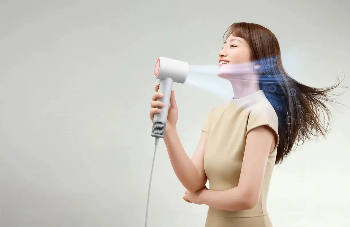 MIJIA H501 SE hair dryer, white with orange nozzle, held by smiling woman — Simples Market
