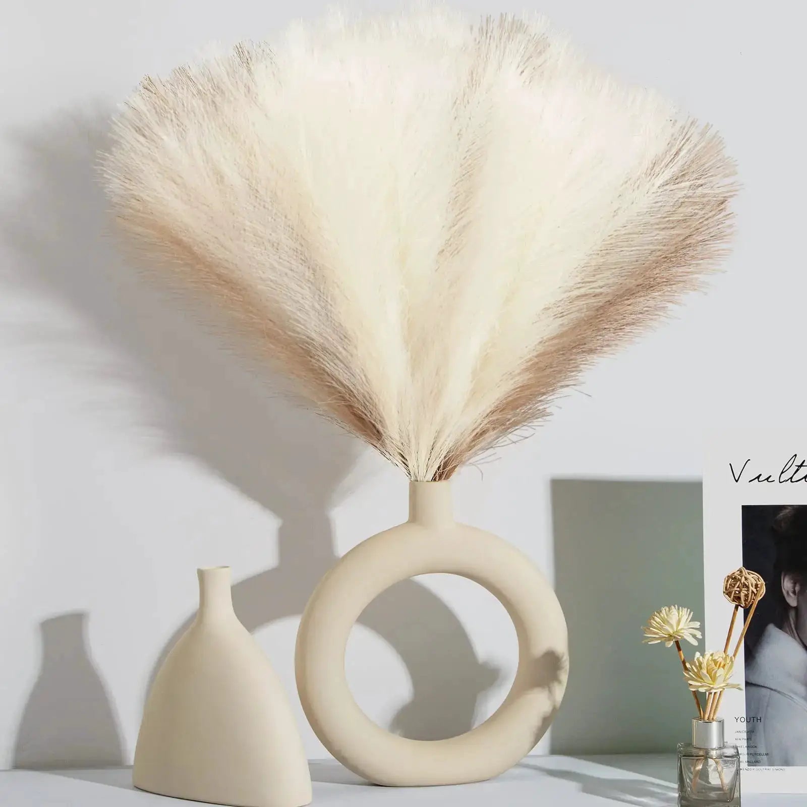 Simples Market artificial pampas grass bouquet in cream fluffy plumes arranged in a modern beige vase with ring handle.