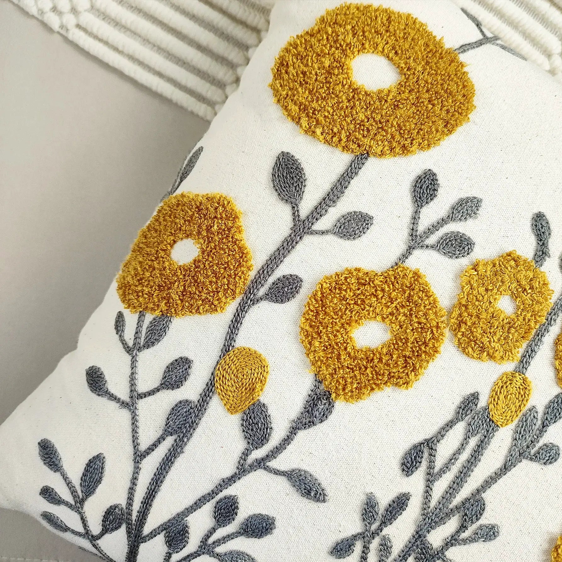 Cushion cover with boho floral tufted embroidery; mustard yellow flowers on gray stems, Simples Market.