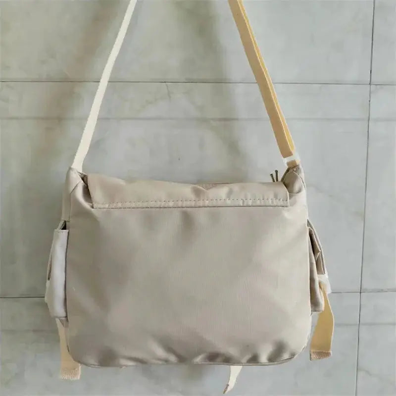Beige canvas crossbody tote bag with long shoulder strap, versatile student bag