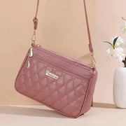 PU leather crossbody bag in pink with quilted diamond pattern and gold hardware by Simples Market