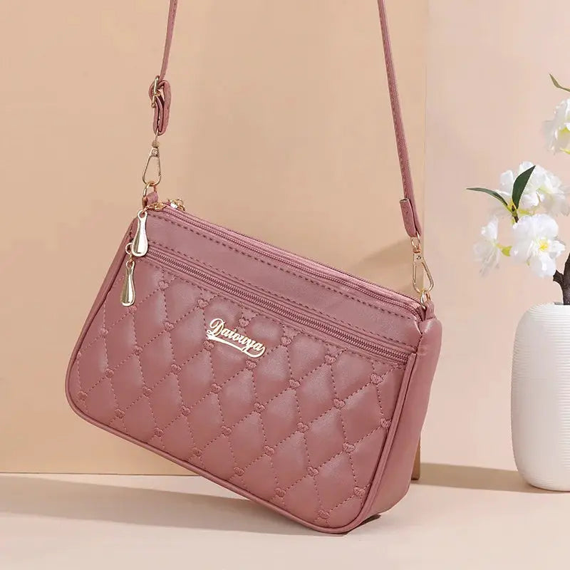 PU leather crossbody bag in pink with quilted diamond pattern and gold hardware by Simples Market