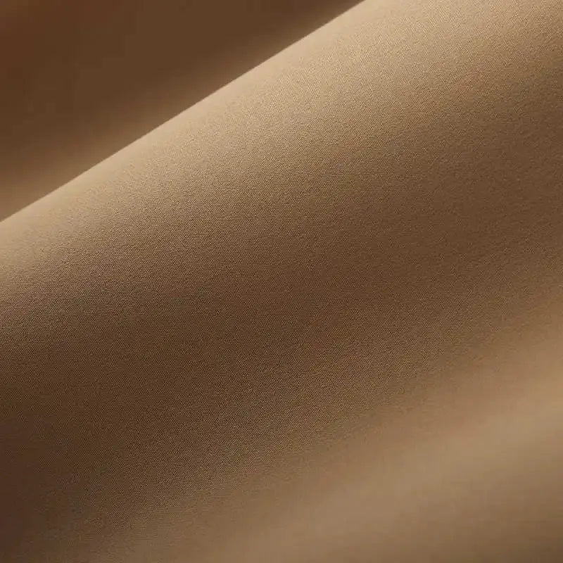 Men's shirt fabric close-up in beige; smooth woven texture