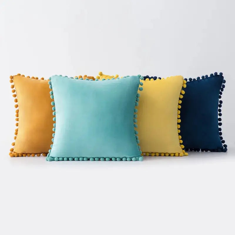 Simples Market velvet cushion covers set of four in teal, turquoise, yellow, and navy with tassel pompom trim