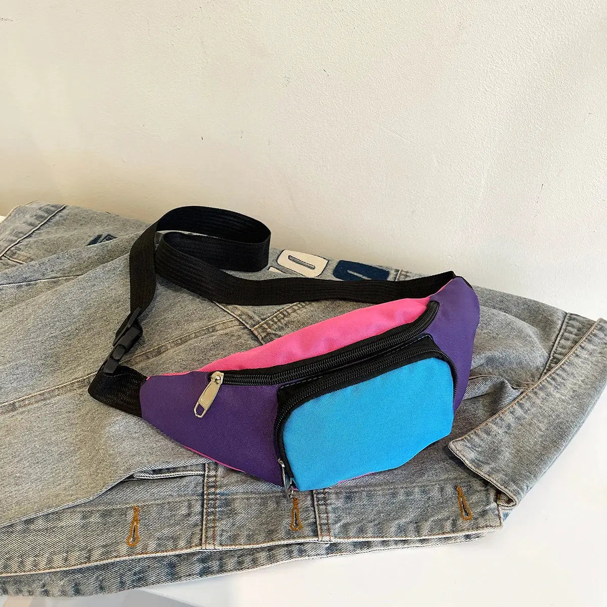 Fanny pack waist bag in pink, purple and blue with black strap and metal zippers