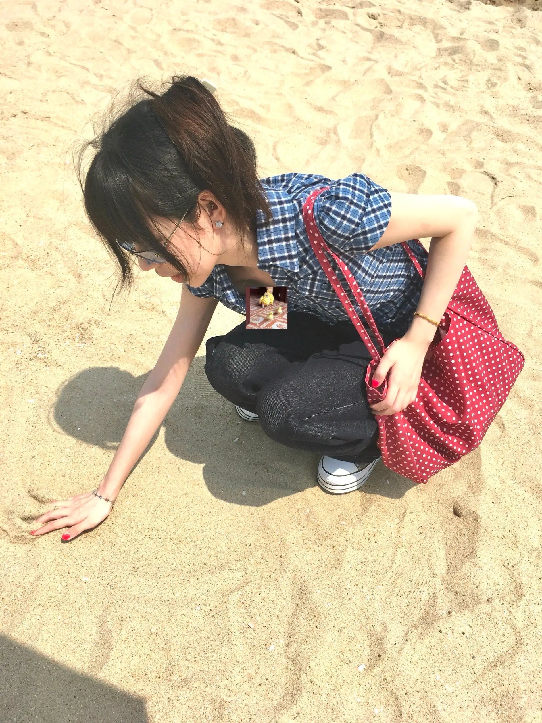 Karrram blue plaid short-sleeve shirt worn by woman on beach with red polka-dot tote