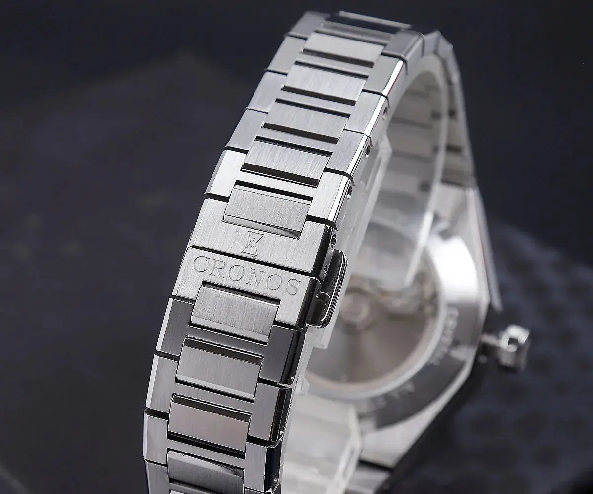 Cronos stainless steel wristwatch with brushed link bracelet and see-through caseback; Cronos logo on the clasp
