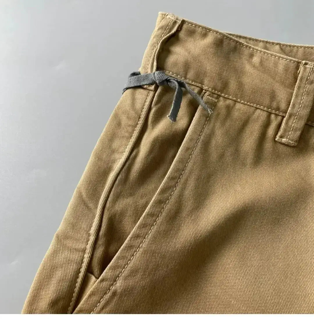 Cargo pants, khaki heavy-duty cotton with drawstring waist and loose straight-leg fit.