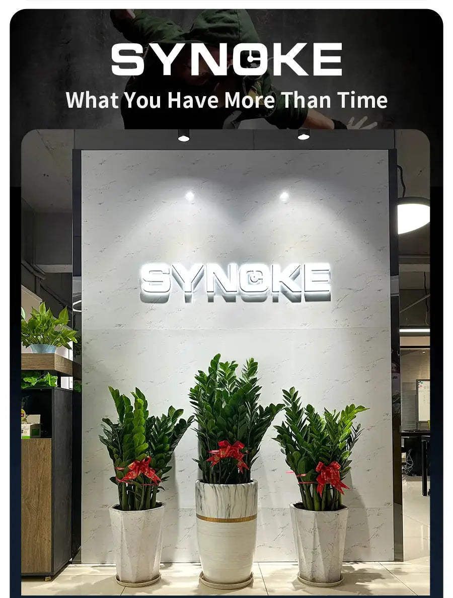 SYNOKE storefront display with illuminated logo on marble wall and three potted plants