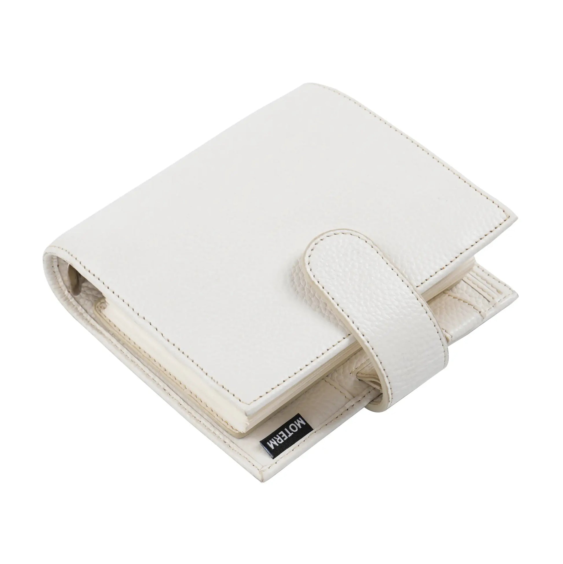 Moterm Luxe 2.0 pocket-size planner in white pebbled leather with strap; Moterm brand tag visible.