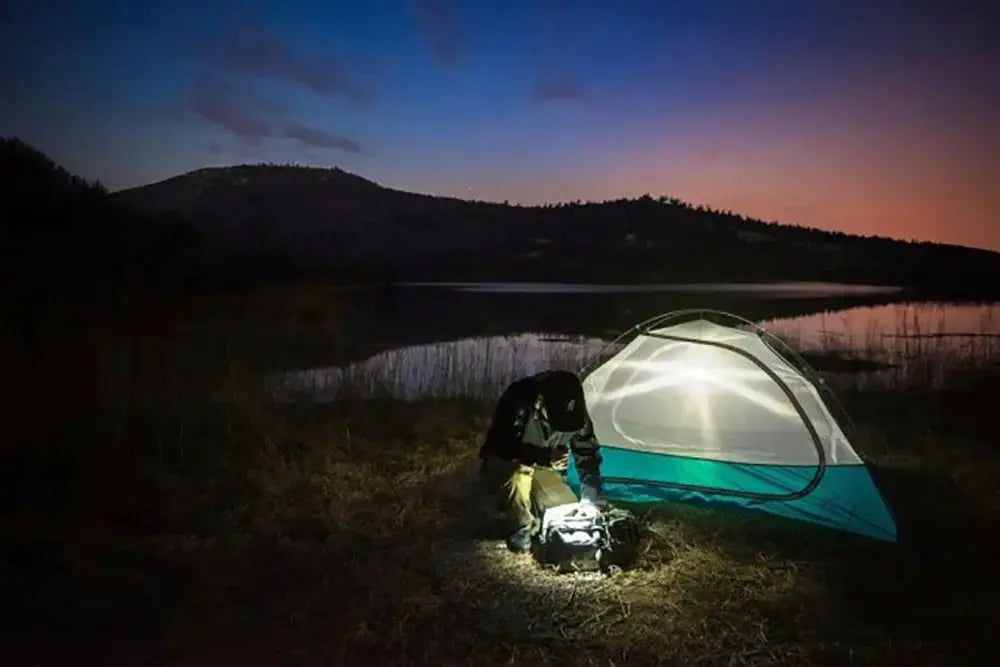 High Power LED Flashlight USB Rechargeable 1000LM, zoomable, waterproof, for outdoor camping, shown beside a tent.