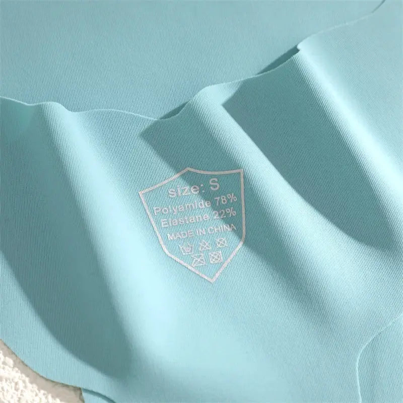 Turquoise seamless women's thong underwear fabric with size S care tag showing polyamide 78% elastane 22%, made in China