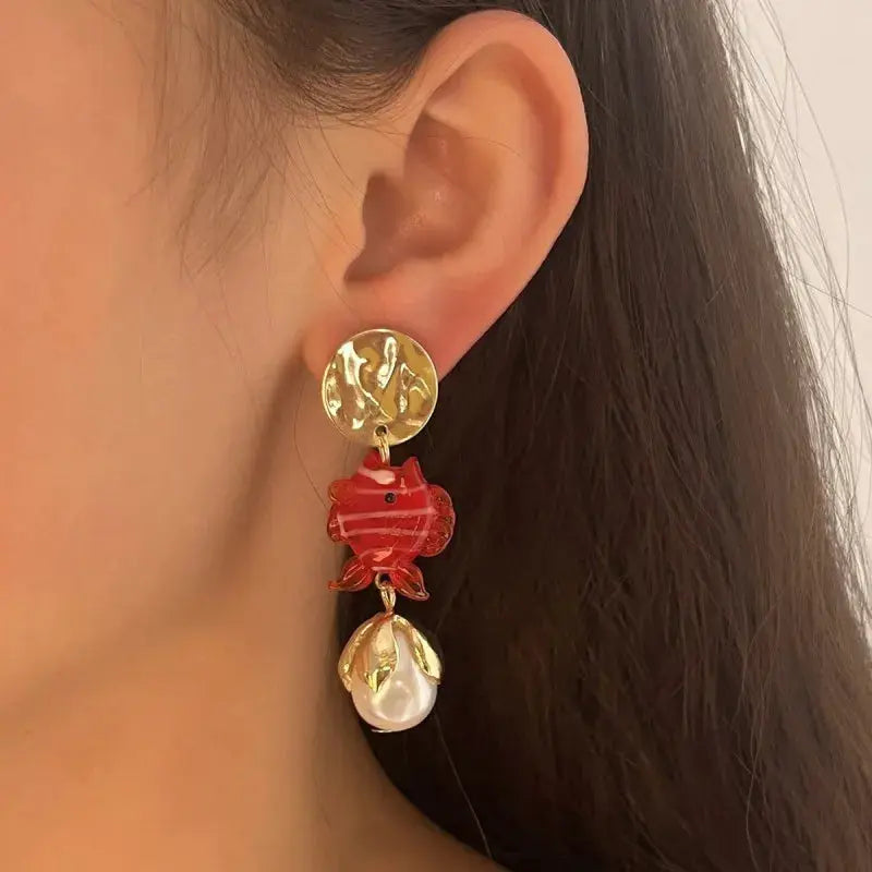 Octopus drop earrings with gold-tone stud, red glass octopus charm, gold-tone leaf accents and pearl pendant