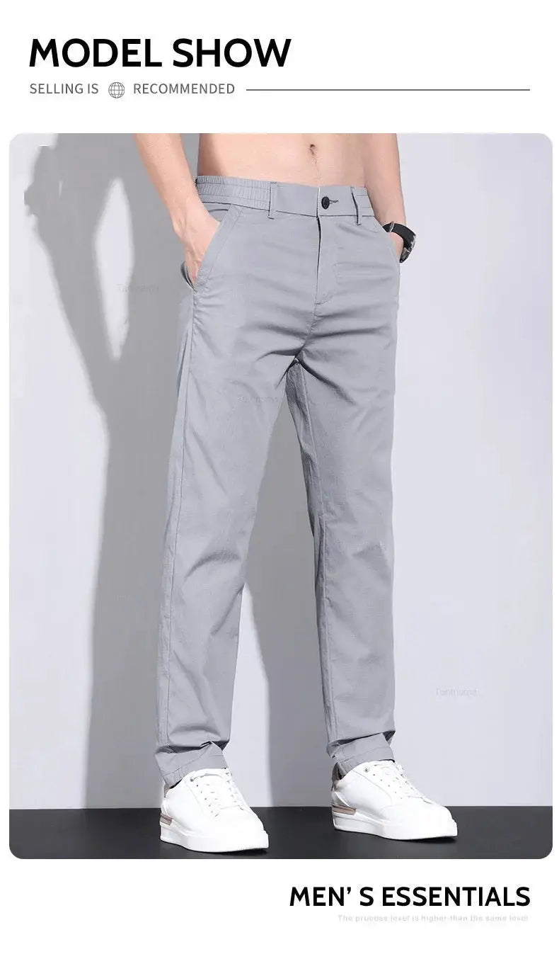 Men's gray slim-straight casual pants with front pockets and rolled cuffs, shown with white sneakers.