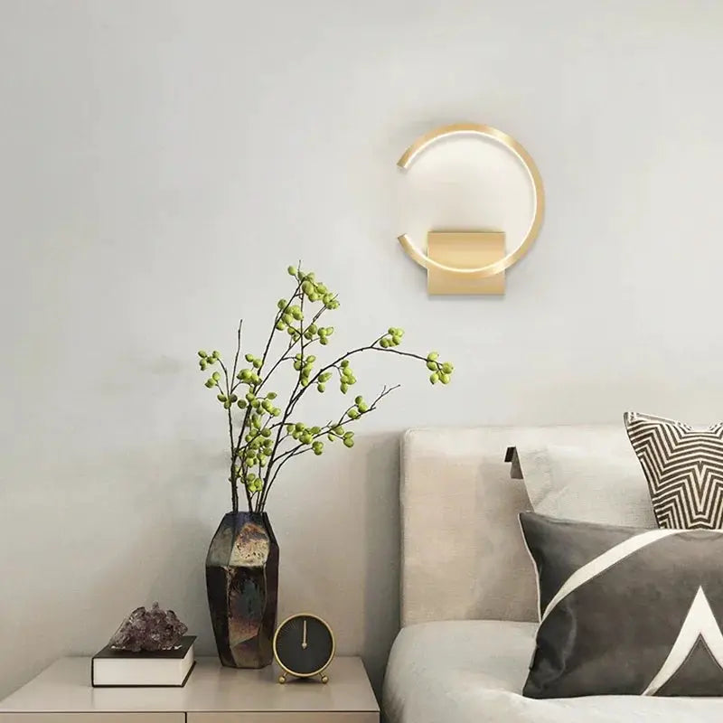 Modern LED wall lamp by Simples Market with a gold circular ring and rectangular base