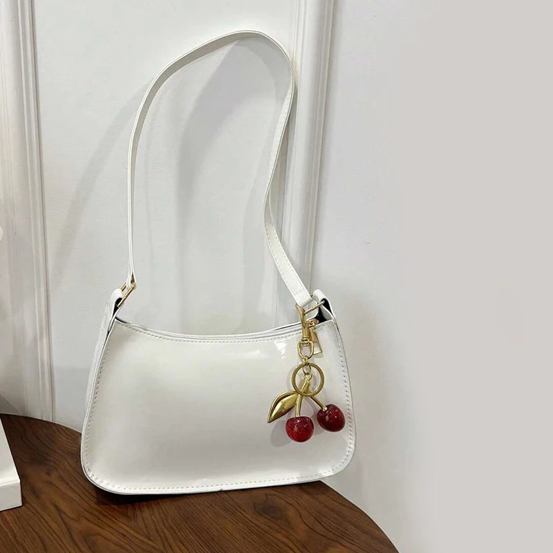 Women's white PU leather shoulder bag with cherry pendant charm and gold hardware