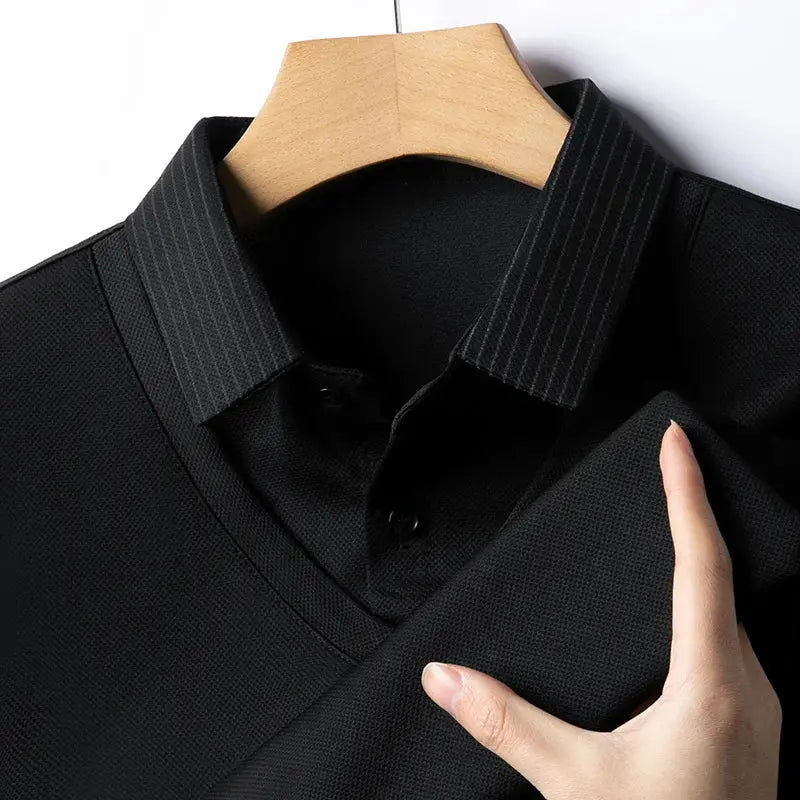 Men's black polo shirt on hanger; solid color, textured knit fabric.