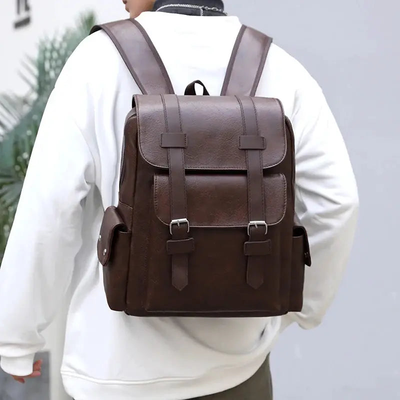 Brown PU leather laptop backpack for men with front buckle straps and side pockets