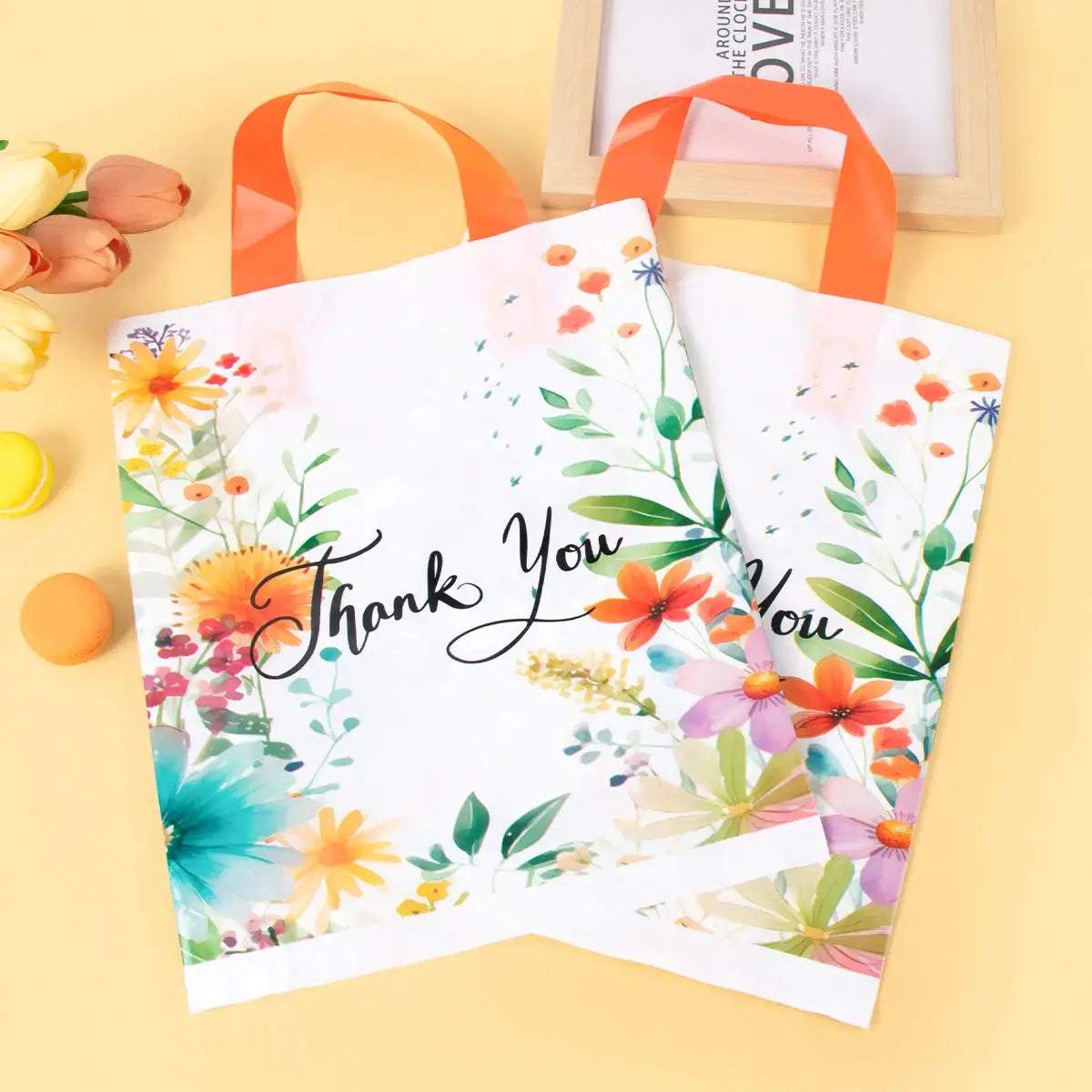 10-pack floral thank-you gift bags with handles, white with colorful blossoms and orange straps