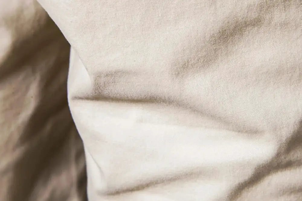 Men's shorts fabric close-up in beige; 100% cotton, solid texture.