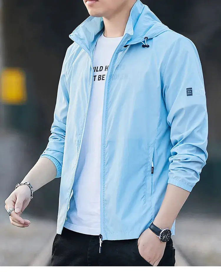 Light blue men's windbreaker with hood, worn over a white tee, breathable lightweight jacket.