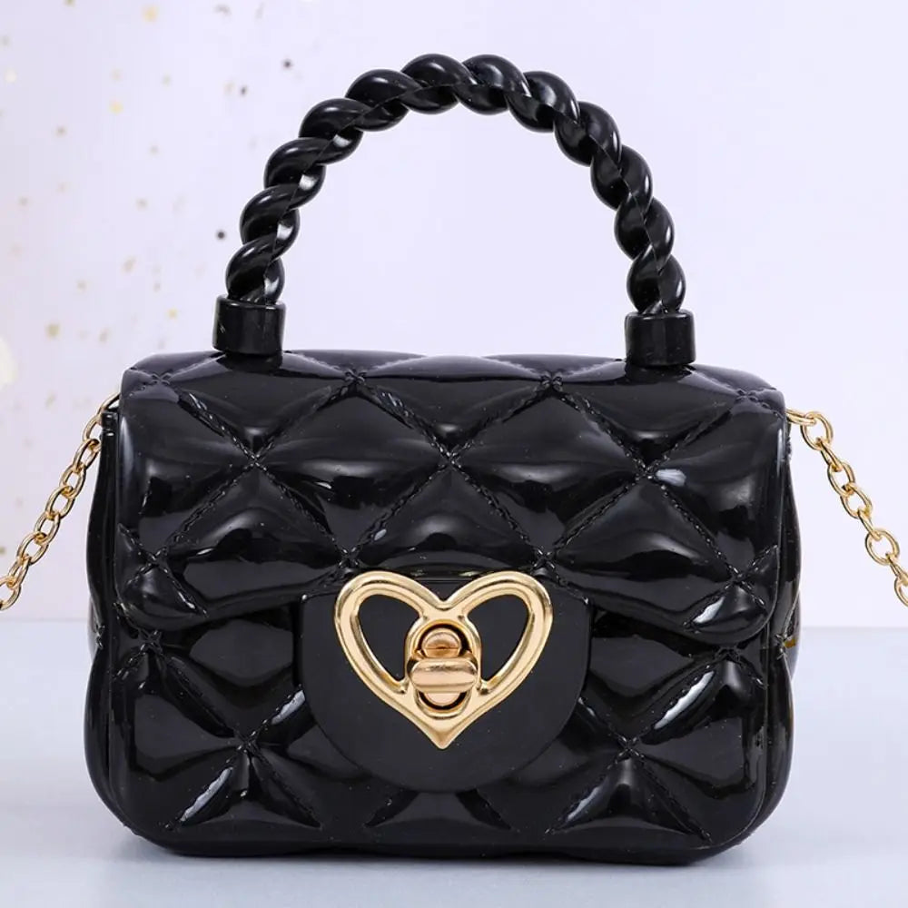 Kids PU leather crossbody bag with black quilted finish, heart-shaped gold clasp, and braided handle