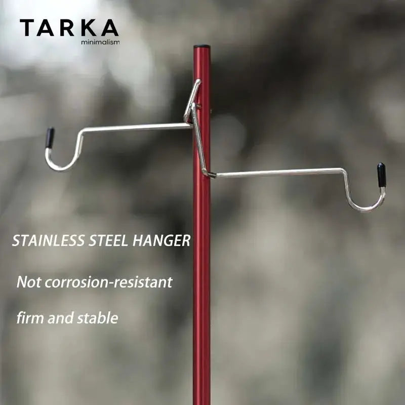 TARKA outdoor light hanger on a red adjustable tabletop stand, stainless steel.