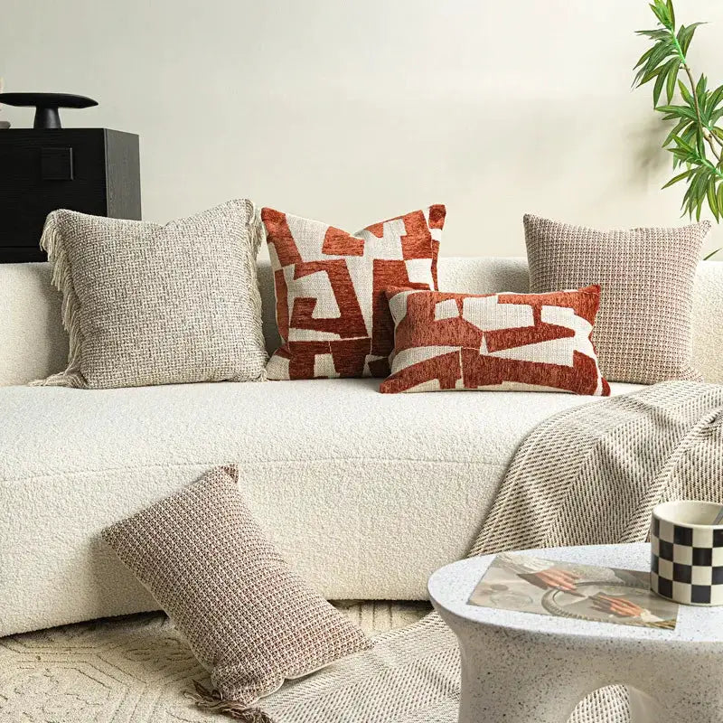 Decorative pillows by Simples Market, set of 5 ivory and rust red cushions on a cream sofa