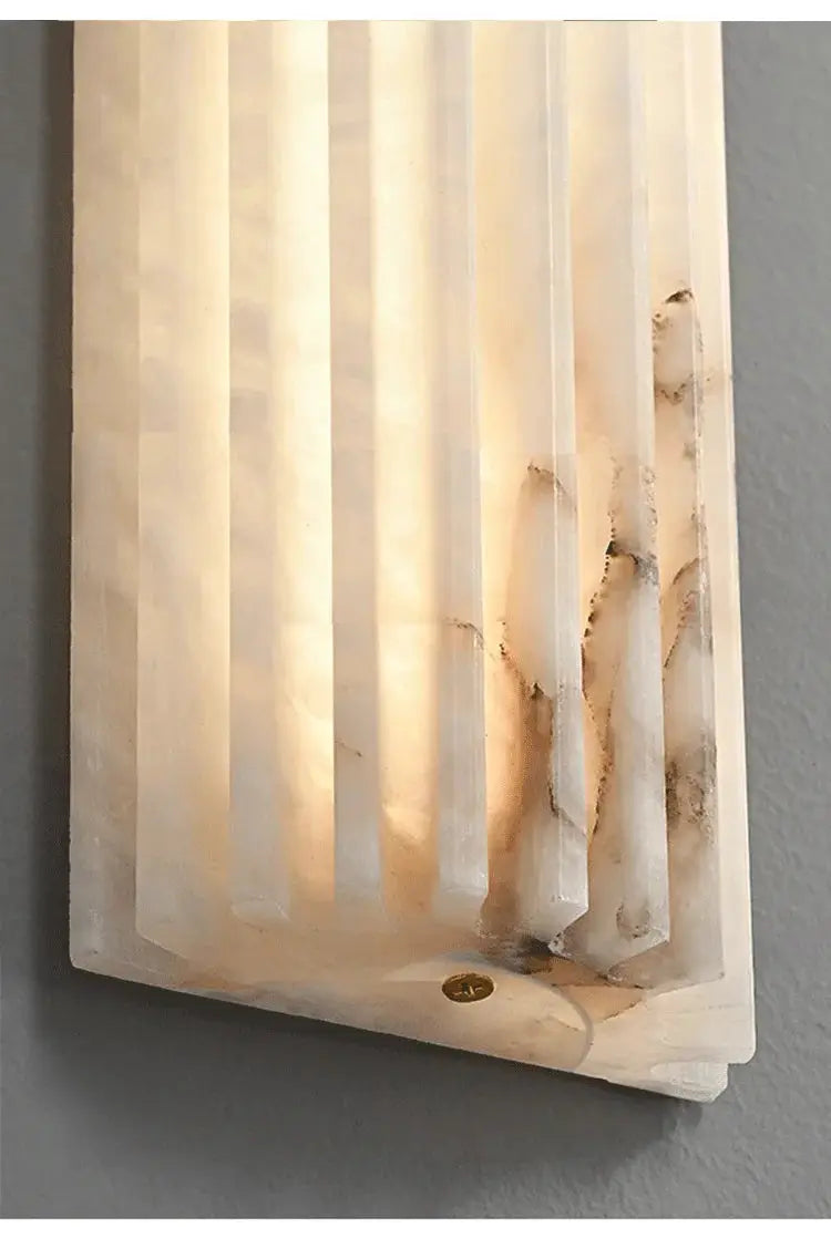 Marble wall lamp sconce with vertical panels in white alabaster, warm glow