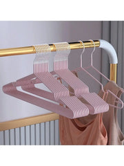 Pink metal seamless anti-slip clothes hangers; multi-piece set on a gold clothing rod.