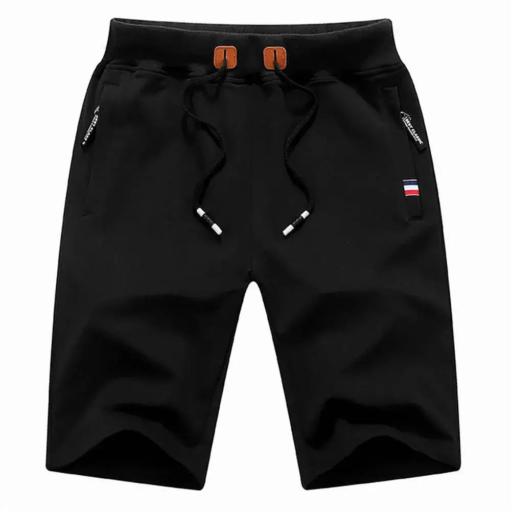 Men's black cotton jogger shorts with drawstring waist, zip pockets, and small flag patch