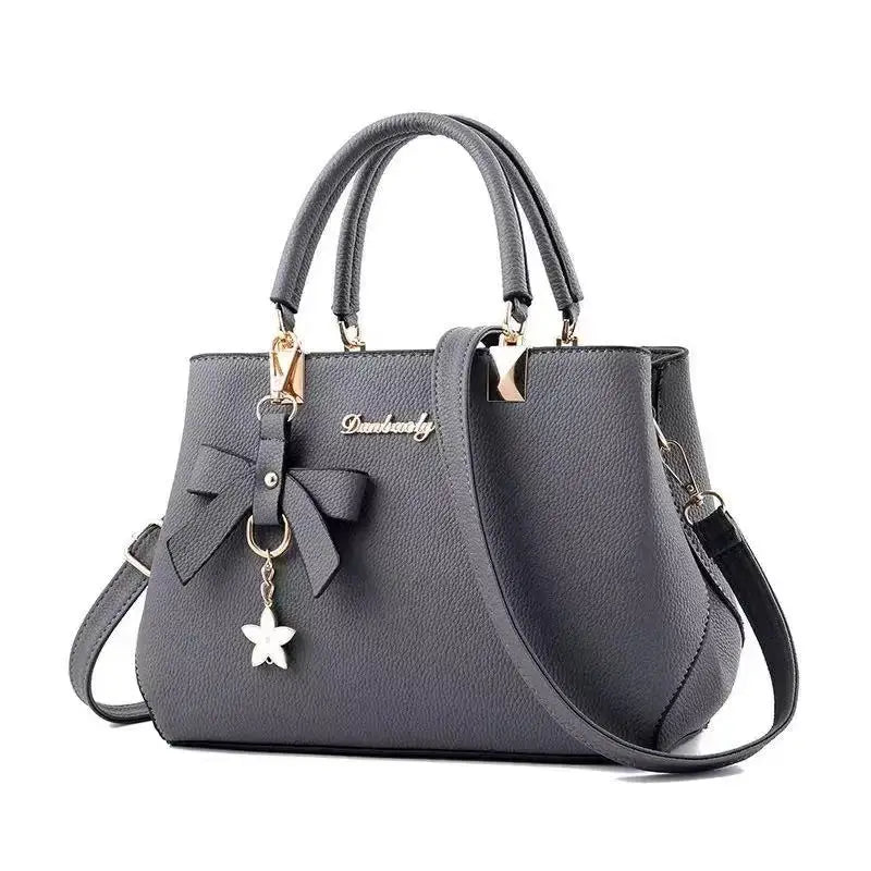 Simples Market gray bow-accent shoulder bag in pebbled faux leather with top handles and detachable crossbody strap