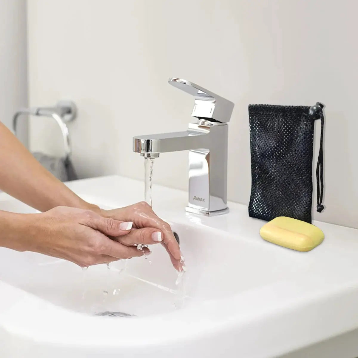 Soap bar case and quick-dry travel soap pouch in black mesh beside a yellow soap bar on a bathroom sink