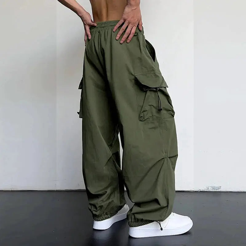 Men's olive green cargo pants with multiple cargo pockets, drawstring waist, and elastic cuffs