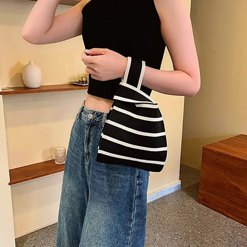 Handwoven handbag by Simples Market; black and white striped mini bag with white trim.