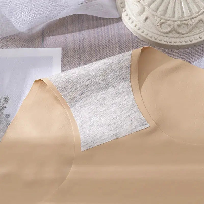 Beige short-sleeve top with a light gray shoulder patch on soft fabric.