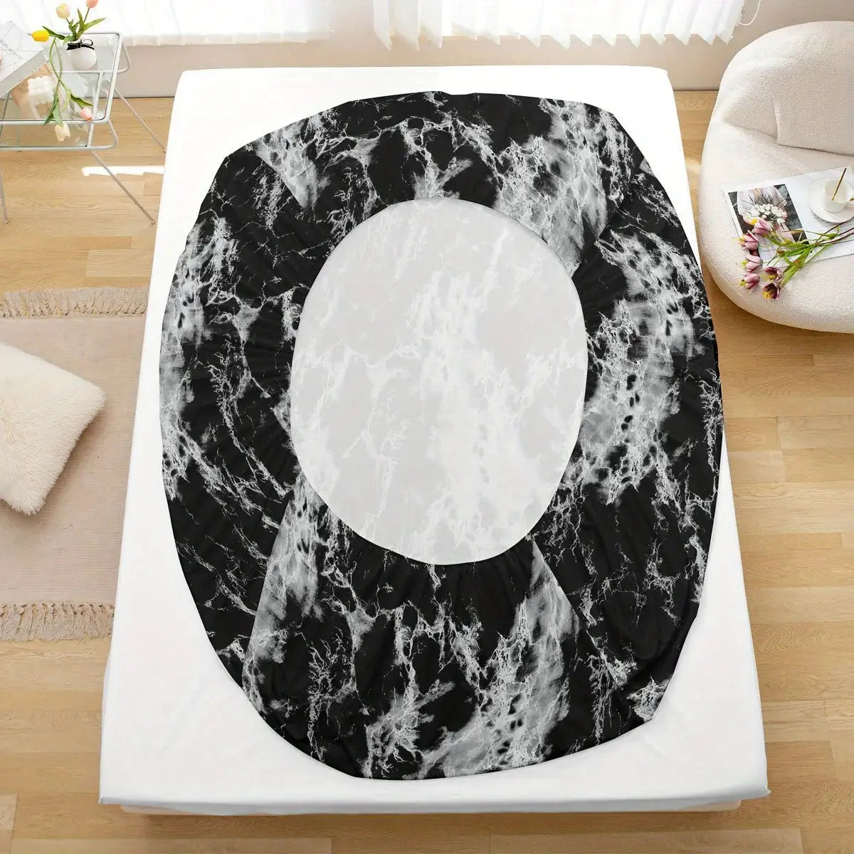 3-Piece marble print fitted sheet set; black marble pattern with white center on a bed