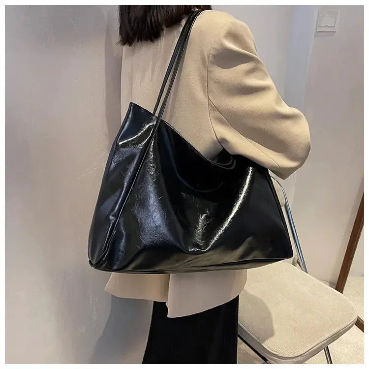 Women tote bag in black soft PU leather with long shoulder strap, large capacity for casual use.